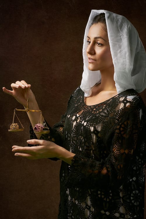 Free Woman in Black Dress Holding Balance Scale Stock Photo