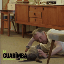 a poster for the guarimba international film festival with a man petting a cat a poster for the guarimba international film festival with a man petting a cat