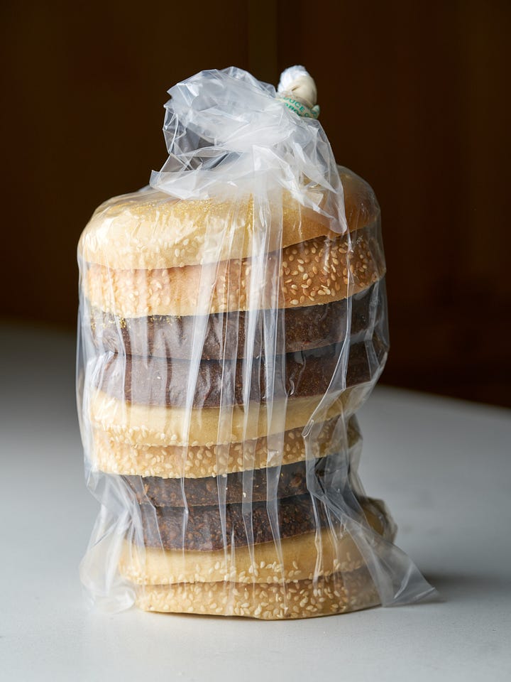 A tower of bagel slices in a freezer bag next to side by side bagel slices in a zipper bag.