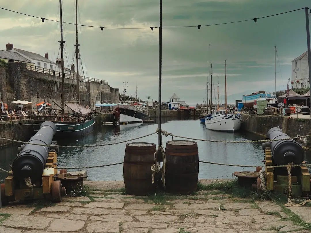 A sailing boat next to a harbour wall