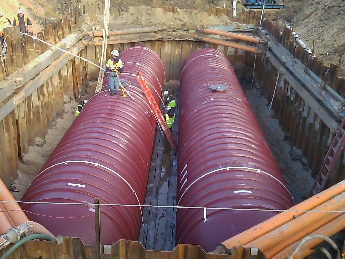 Newly installed fiberglass-reinforced plastic tanks with humans for scale