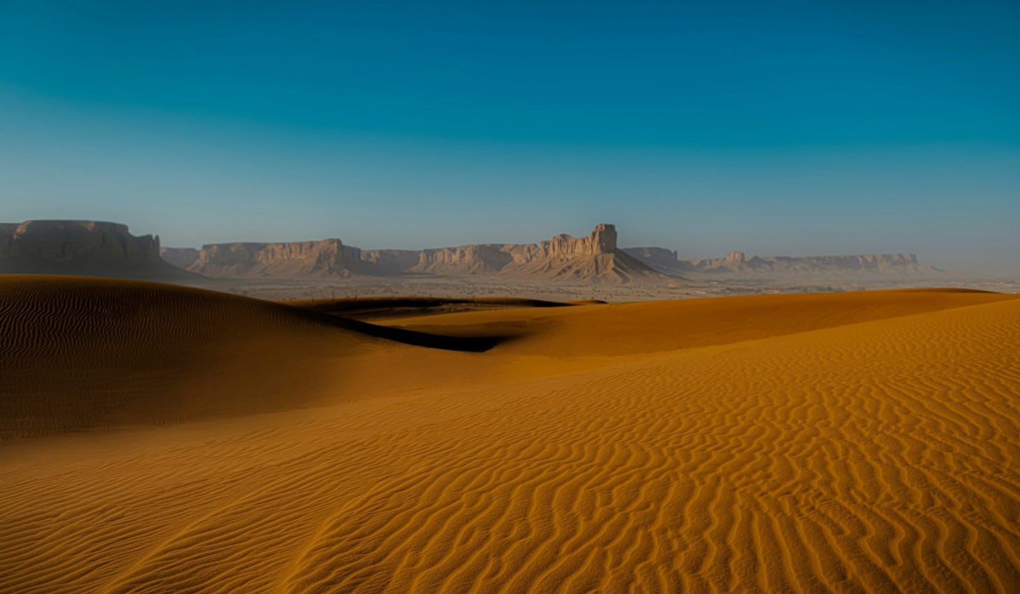 Golden sand dunes stretching across the Rub’ al Khali desert in Saudi Arabia under a clear blue sky, illustrating one of the world’s largest continuous sand deserts