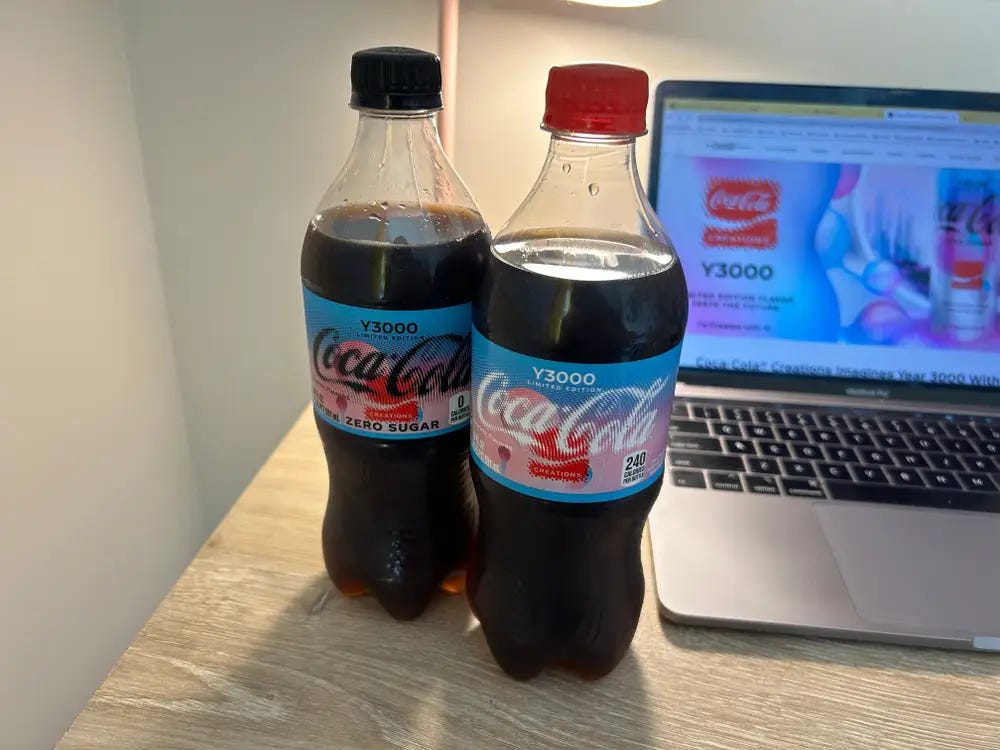 Duas coca cola y300, uma normal e outra zero posicionadas ao lado de um notebook.
