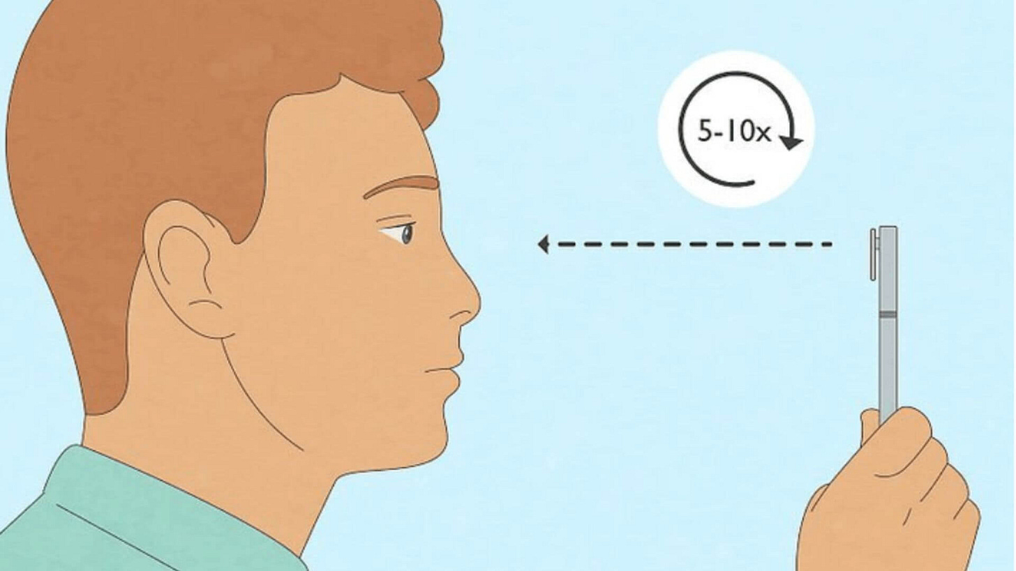 Person practicing near and far focus exercise by alternating visual attention between their thumb held close and a distant object