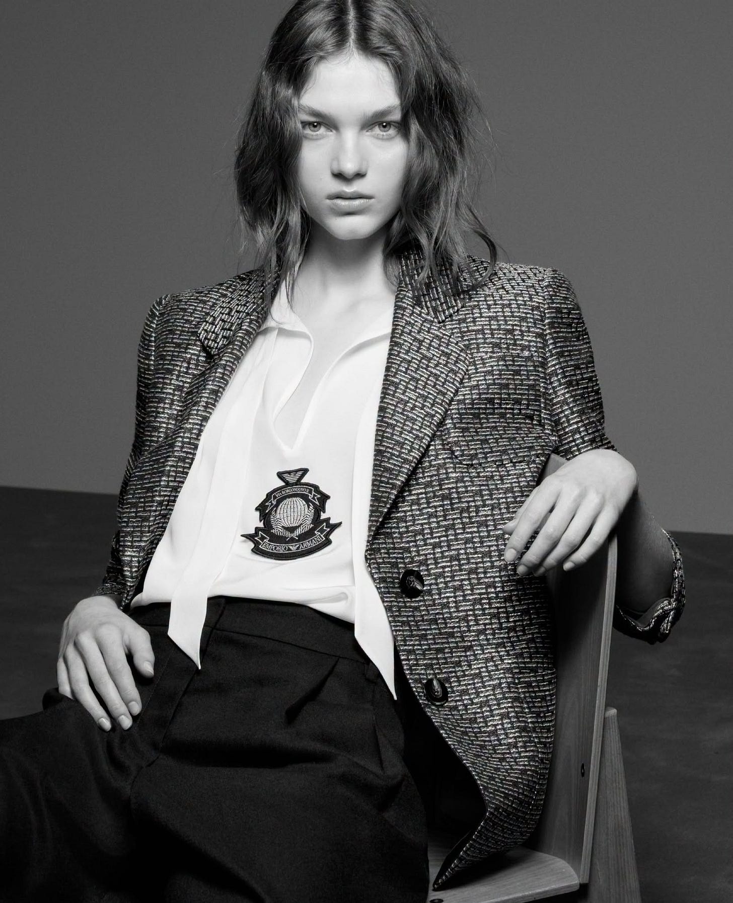 Model wearing Emporio Armani houndstooth blazer with crest emblem from the Fall-Winter 2026-27 collection