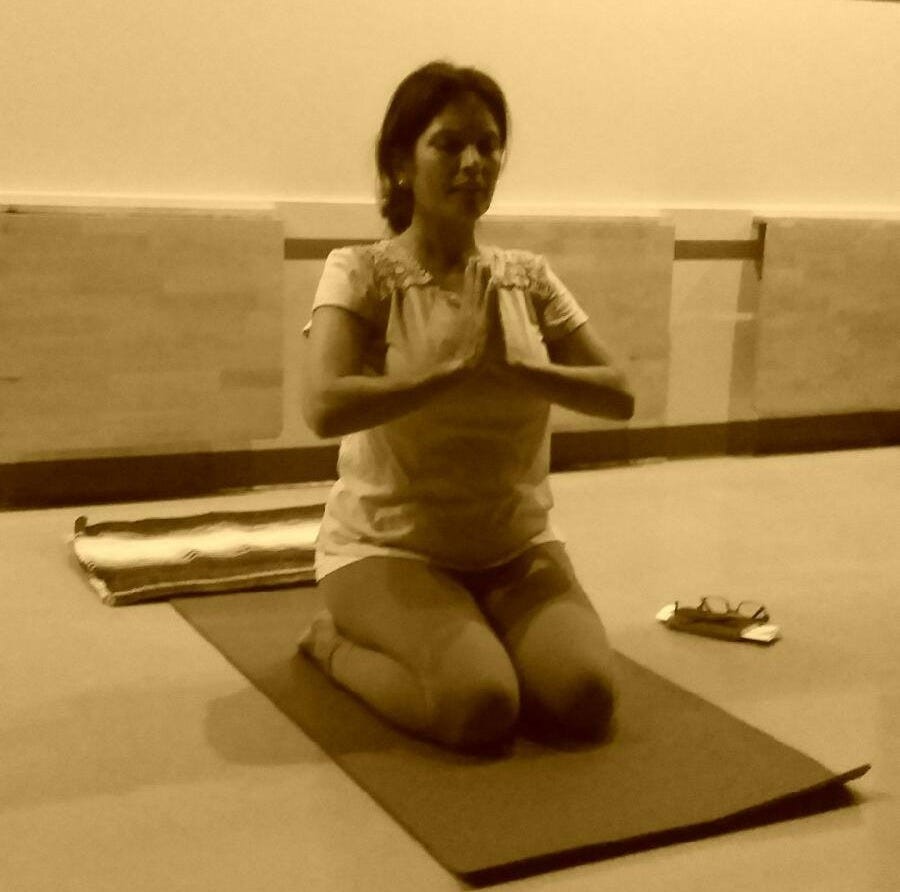 Anu seated in Virasana in yoga class
