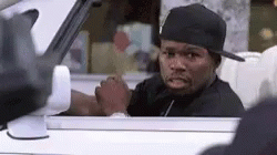 a man in a hat is sitting in a car with a cat looking out the window .