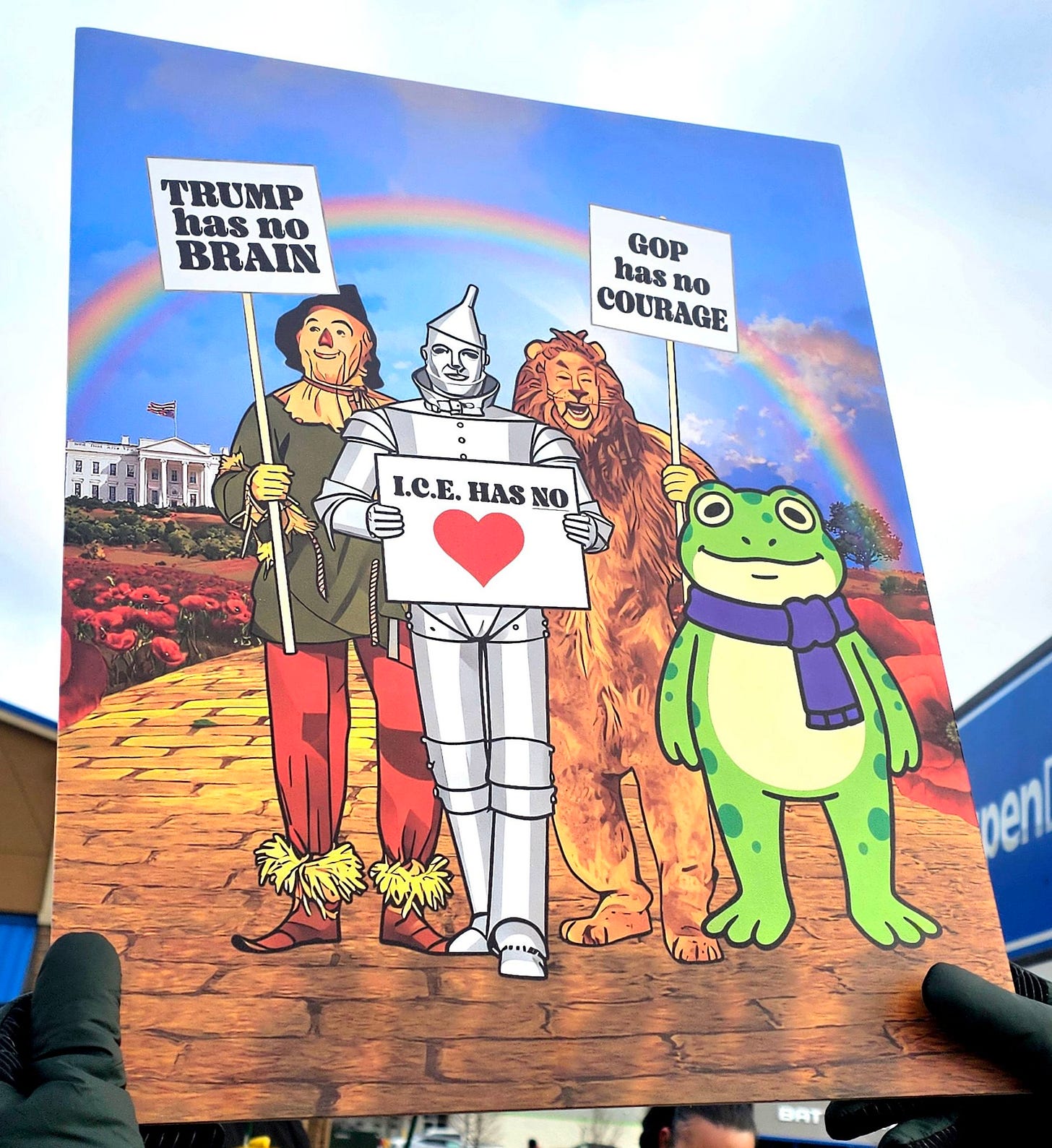 Protest sign with Wizard of Oz characters holding messages: “TRUMP has no BRAIN,” “GOP has no COURAGE,” and “I.C.E. HAS NO ❤️