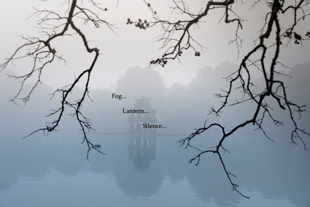 a foggy lake with a building in the distance