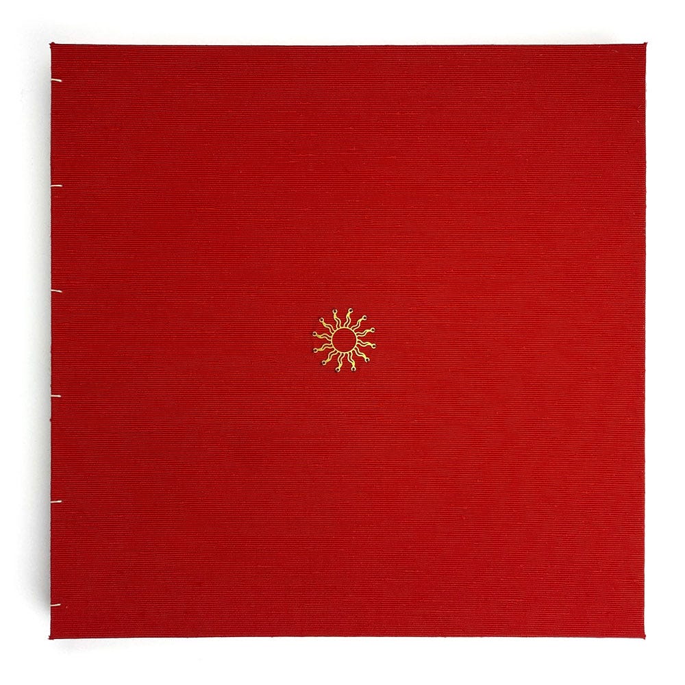 Square cover lined with red silk, with a small metallic sun sewn in the centre.