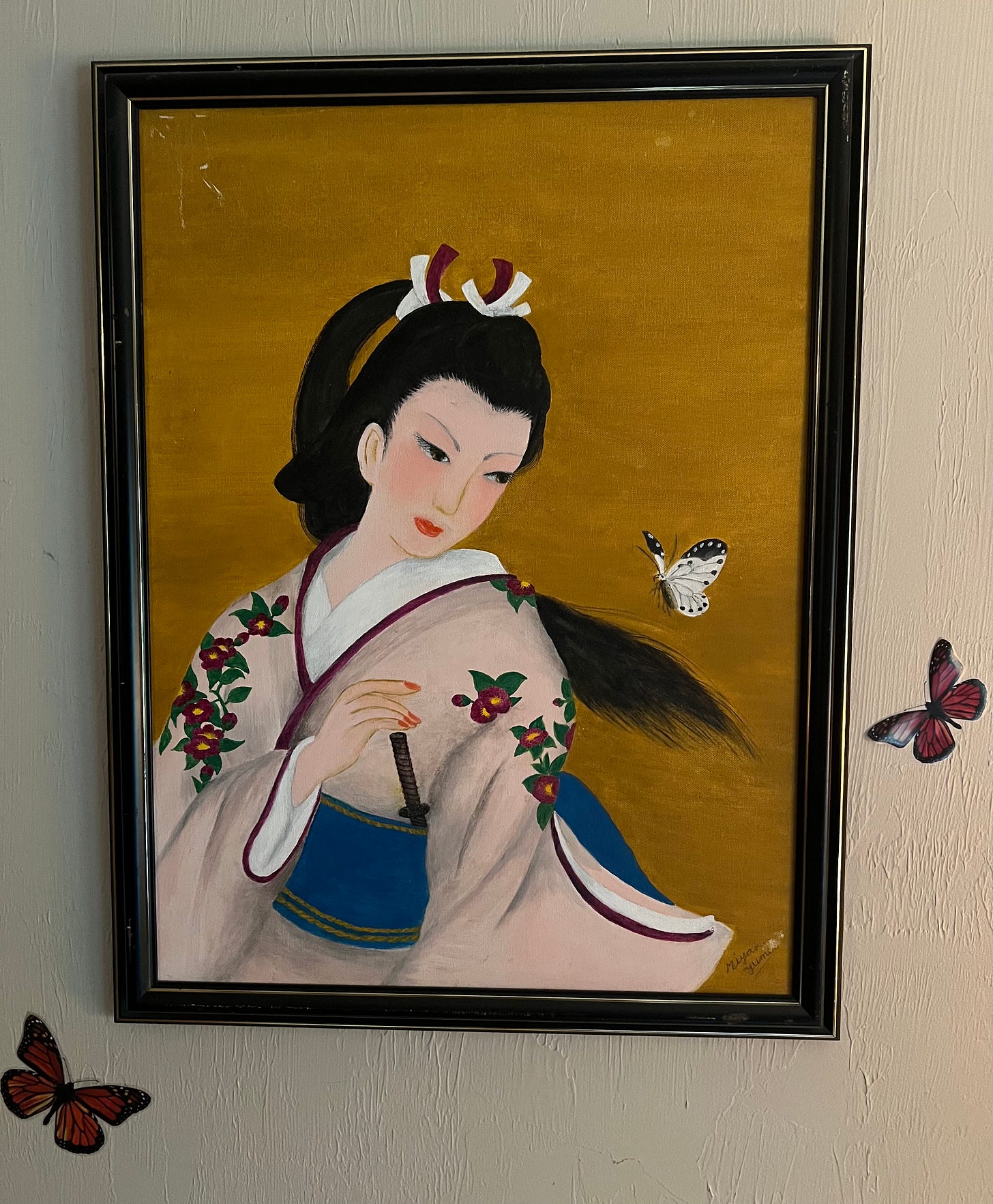One of my mother's paintings probably painted in the 1970's, a beautiful Asian woman (goddess) wearing a light pale rose kimono with deep red flowers, a blue obi. She has long hair and is looking over her to her left at a butterfly. 