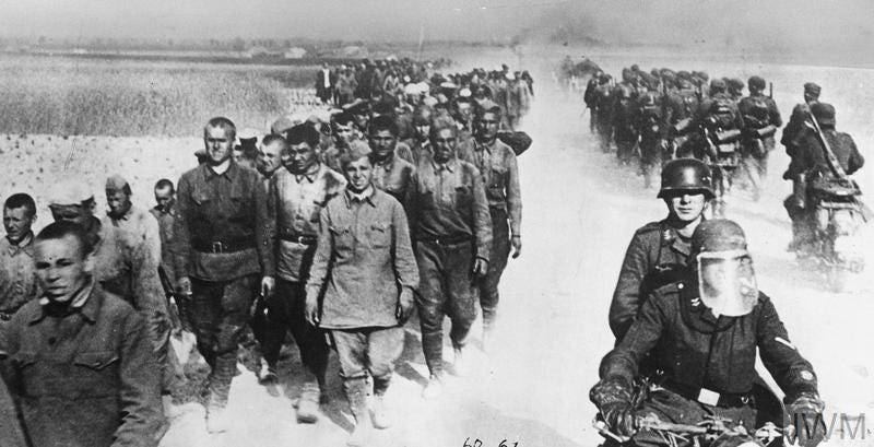 German motorcycle troops and infantry pass a long column of Russian prisoners during the advance into the Soviet Union, 1941.
