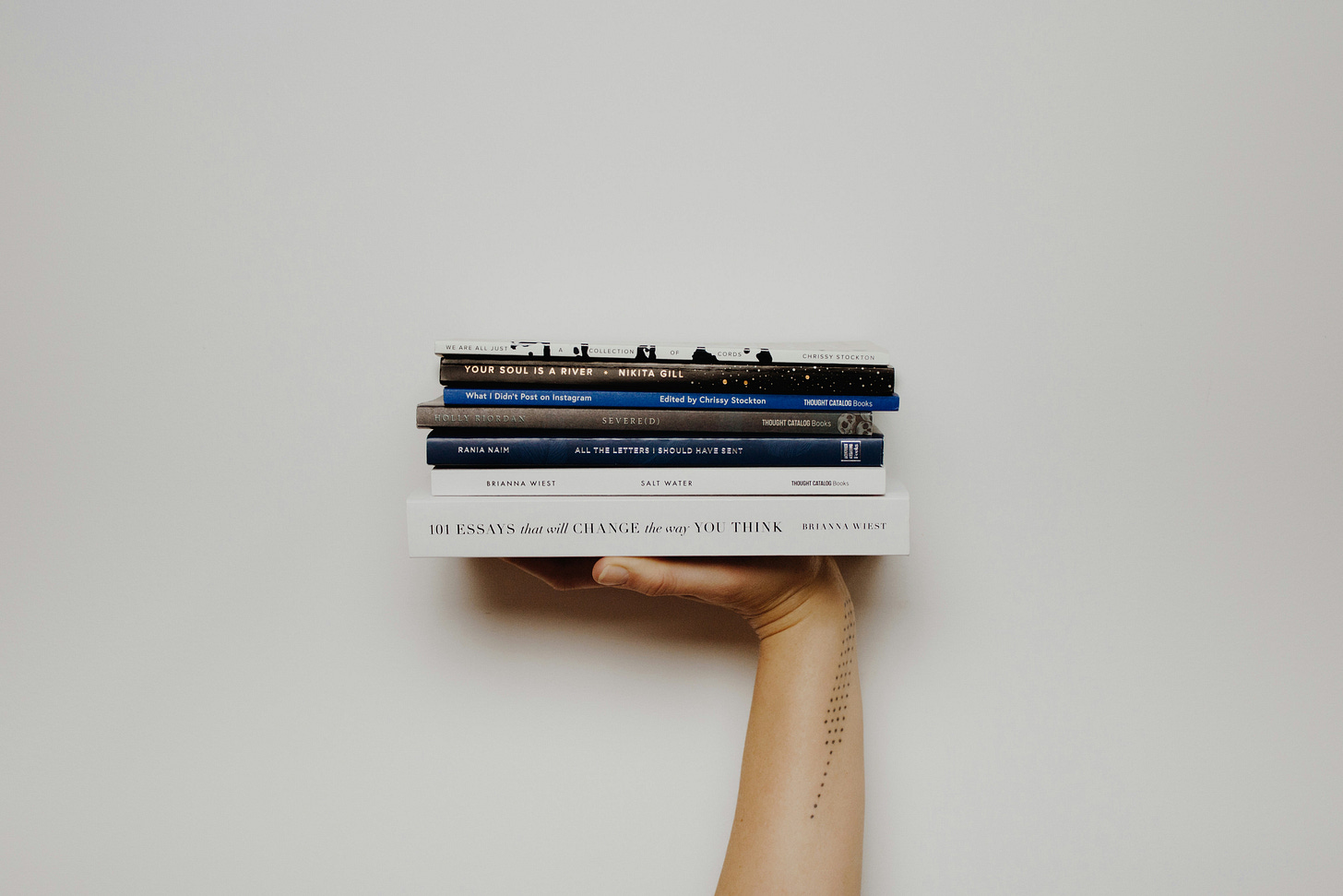 hand holding a stack of books hand holding a stack of books