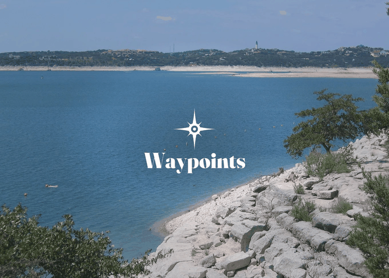 An animated banner cycling through various scenic locations. The first frame shows a wide view of Lake Travis under a hazy blue sky, with deep blue water meeting a rocky limestone shoreline in the foreground and low tree-covered hills along the far bank. The Waypoints logo, a white compass-star above the word "Waypoints" in serif type, is centered over the scenery. An animated banner cycling through various scenic locations. The first frame shows a wide view of Lake Travis under a hazy blue sky, with deep blue water meeting a rocky limestone shoreline in the foreground and low tree-covered hills along the far bank. The Waypoints logo, a white compass-star above the word "Waypoints" in serif type, is centered over the scenery.