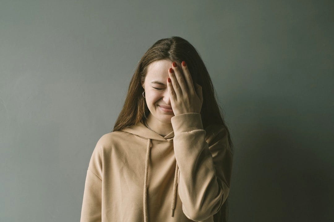 a woman covering her face with her hands a woman covering her face with her hands