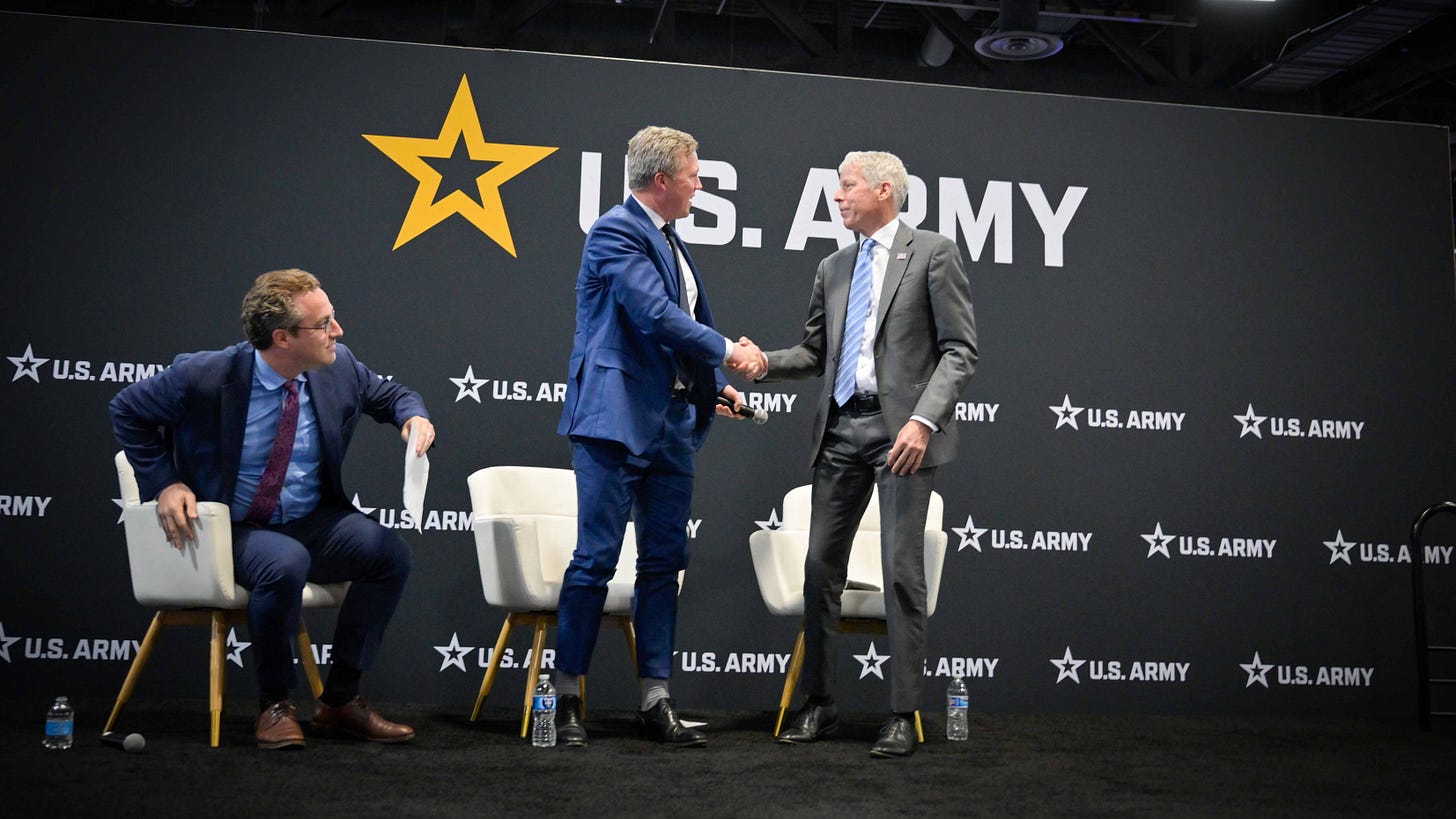 Army Secretary Dan Driscoll and Energy Secretary Christopher Wright shake hands at an AUSA 2025 event.