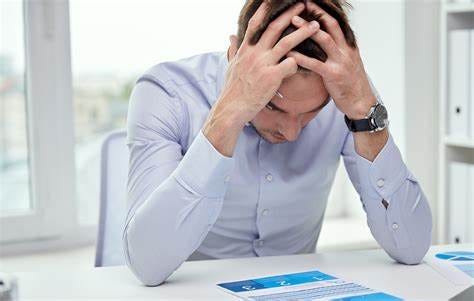 stressed businessman with papers in office | IT Exchange