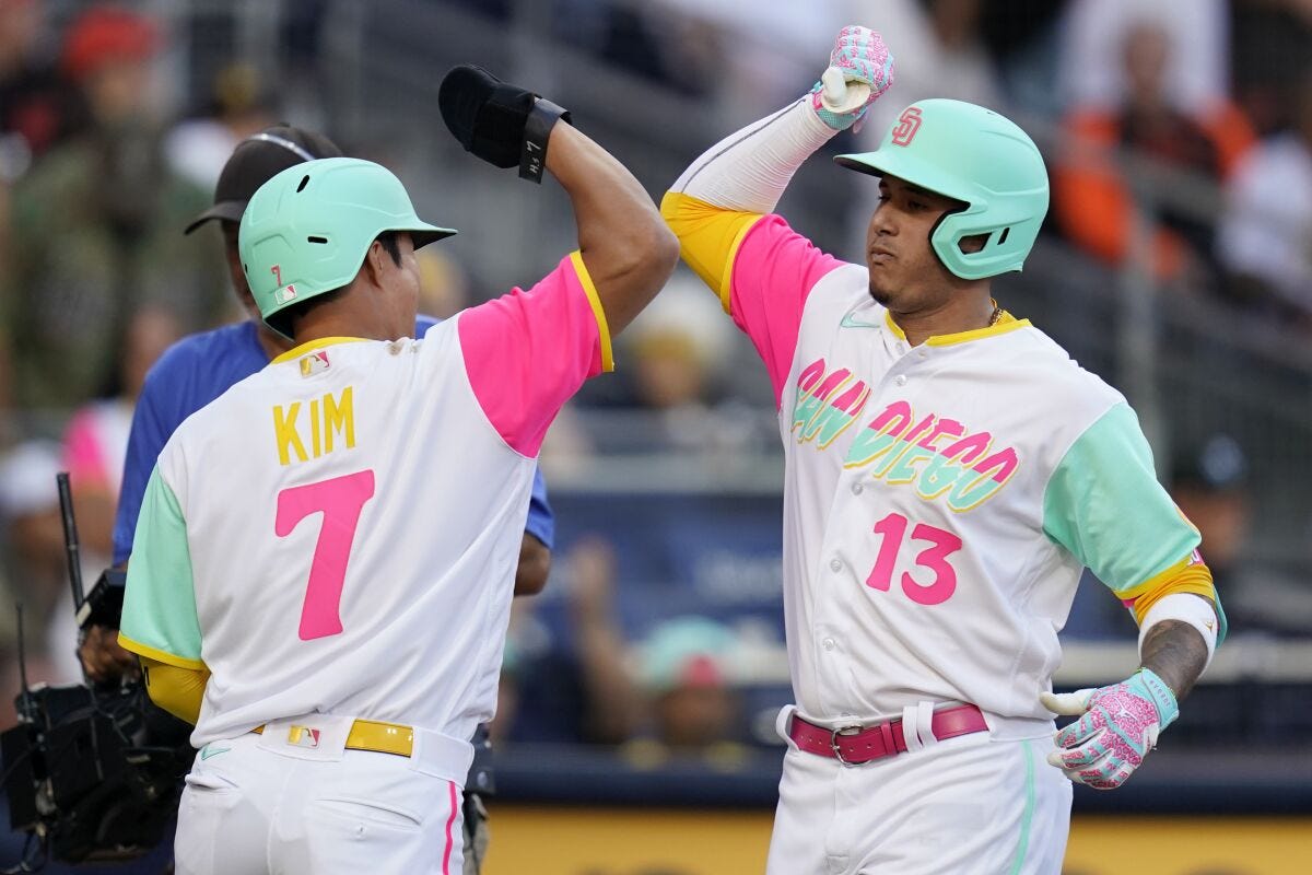 San Diego Padres' Manny Machado (13) celebrates with teammate Ha-Seong Kim (7).