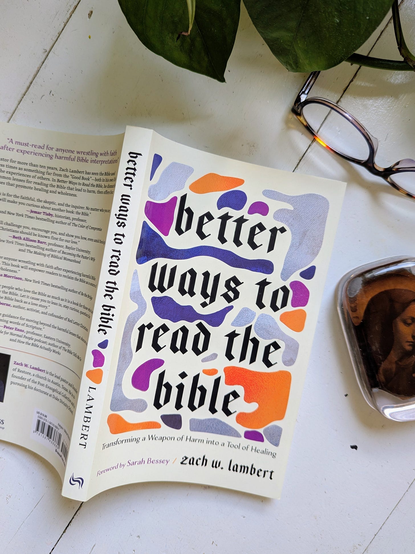 Better Ways to Read the Bible, shown with plant foliage, reading glasses, and a paperweight with an image of Mary, Jesus's mother.