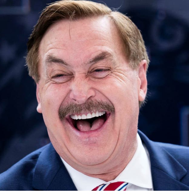 A person in a suit laughing

Description automatically generated