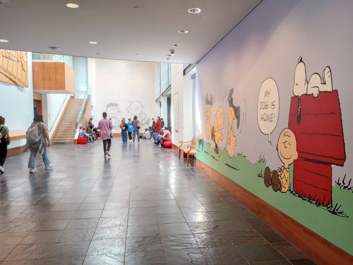 Visitors in main concourse of first floor, with cartoons on walls Visitors in main concourse of first floor, with cartoons on walls