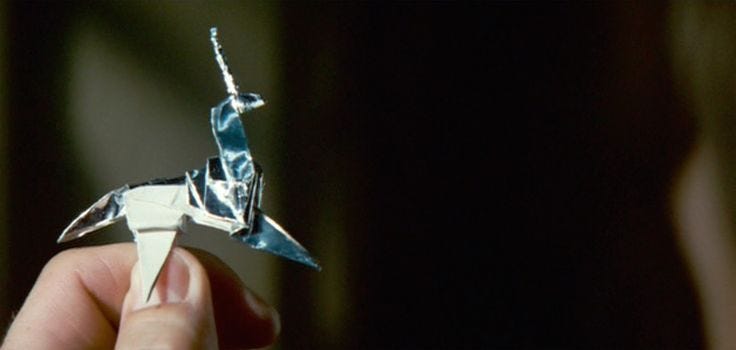 This may contain: a person is holding a origami bird in their hand and looking at it