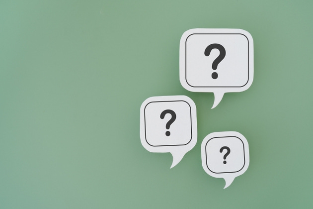 For FAQ , Frequently asked questions concept, asked questions and answers. Question mark on different size of white speech bubble real paper cut on green background, copy space included