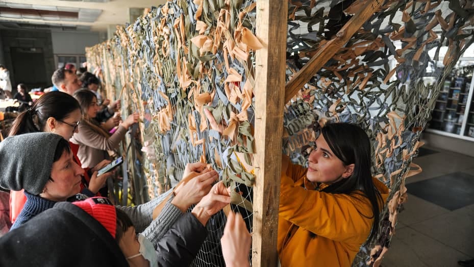 Ukrainian volunteers weave camouflage nets while helping to set up a defense position for Ukrainian soldiers in Lviv on Feb. 26.