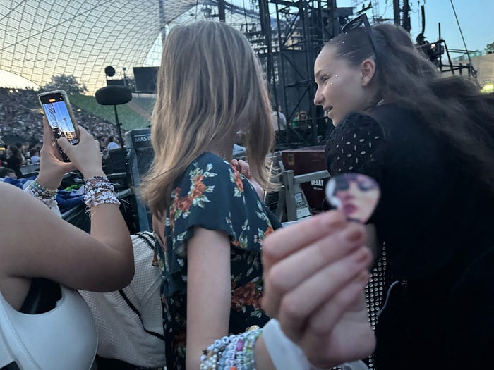 The back of my daughter’s head and she shows me her Taylor guitar pick