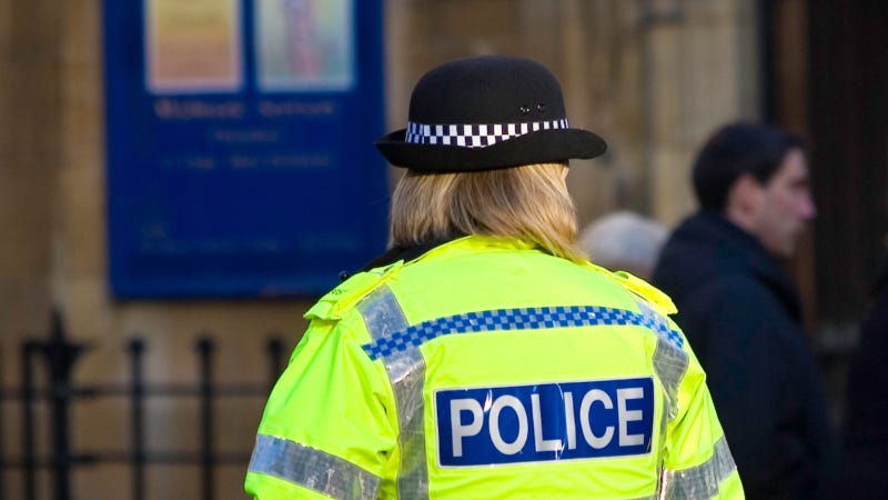 A female police officer seen from behind, standing outdoors