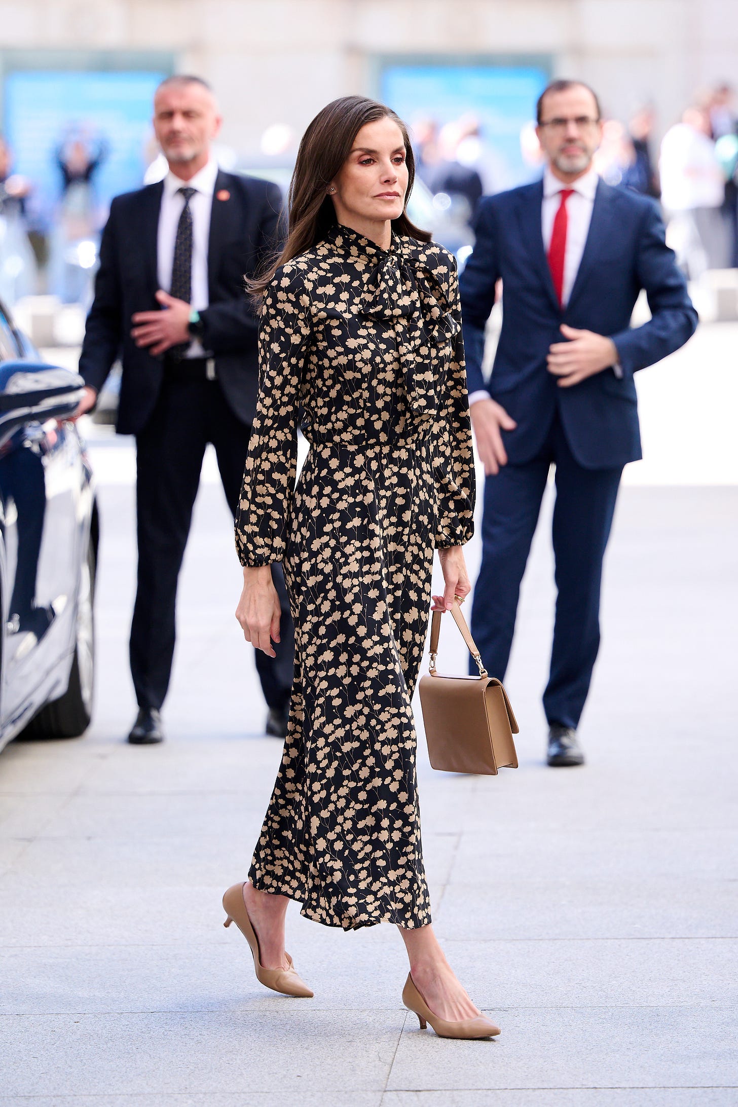 Woman in black and white dress carrying handbag