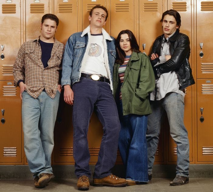 This may contain: four young men standing in front of lockers