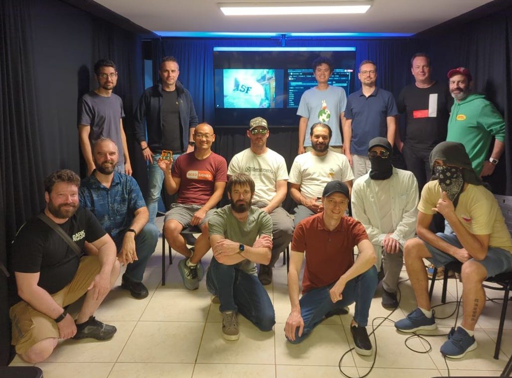 Group photo of the summit attendees at Casa 21 in São Paulo, roughly seventeen developers posed in front of a presentation screen. Several have their faces covered for privacy. Group photo of the summit attendees at Casa 21 in São Paulo, roughly seventeen developers posed in front of a presentation screen. Several have their faces covered for privacy.