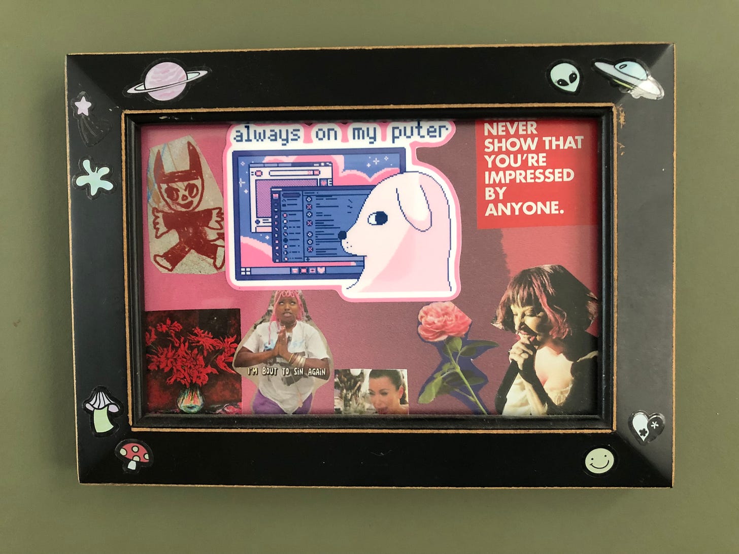A 4”x6” picture frame with a collage inside (collages are Emory’s favorite form of mess). Images in the collage include a devilish doodle, a still life of a bouquet of flowers, Flyana Boss’s prayer hands as she says, “I’m ‘bout to sin again,” Kim K crying, a rose, Lady Gaga, a dog in front of a computer screen with the text “always on my puter” above him (a gift from my friend A), and the phrase, “NEVER SHOW THAT YOU’RE IMPRESSED BY ANYONE.” A 4”x6” picture frame with a collage inside (collages are Emory’s favorite form of mess). Images in the collage include a devilish doodle, a still life of a bouquet of flowers, Flyana Boss’s prayer hands as she says, “I’m ‘bout to sin again,” Kim K crying, a rose, Lady Gaga, a dog in front of a computer screen with the text “always on my puter” above him (a gift from my friend A), and the phrase, “NEVER SHOW THAT YOU’RE IMPRESSED BY ANYONE.”