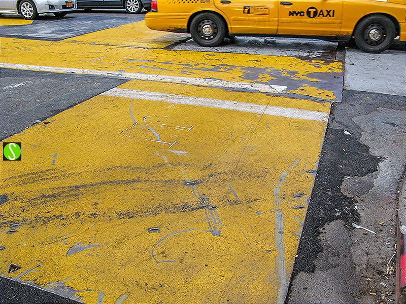 photo of New York cab in city traffic over yellow road plates 2011