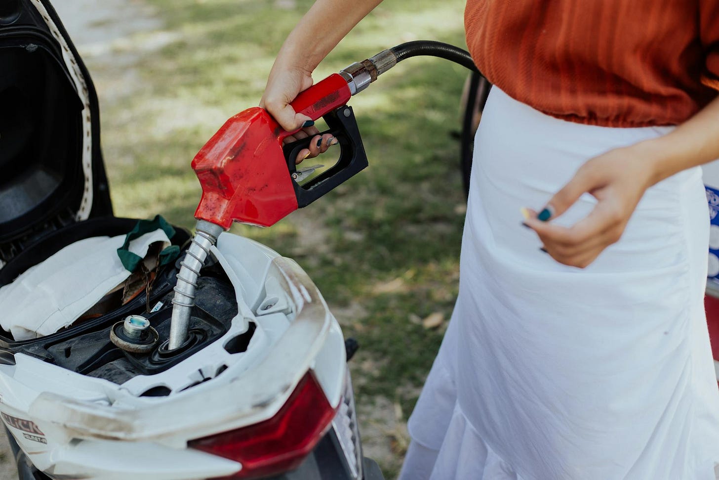 Woman refueling a motorcycle Woman refueling a motorcycle