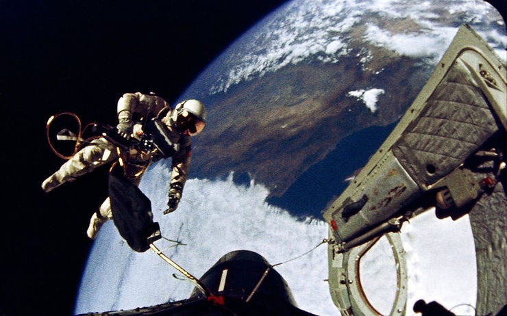 Astronaut in a white suit performs a spacewalk outside a spacecraft. Earth is visible in the background with clouds and landmasses. Astronaut in a white suit performs a spacewalk outside a spacecraft. Earth is visible in the background with clouds and landmasses.