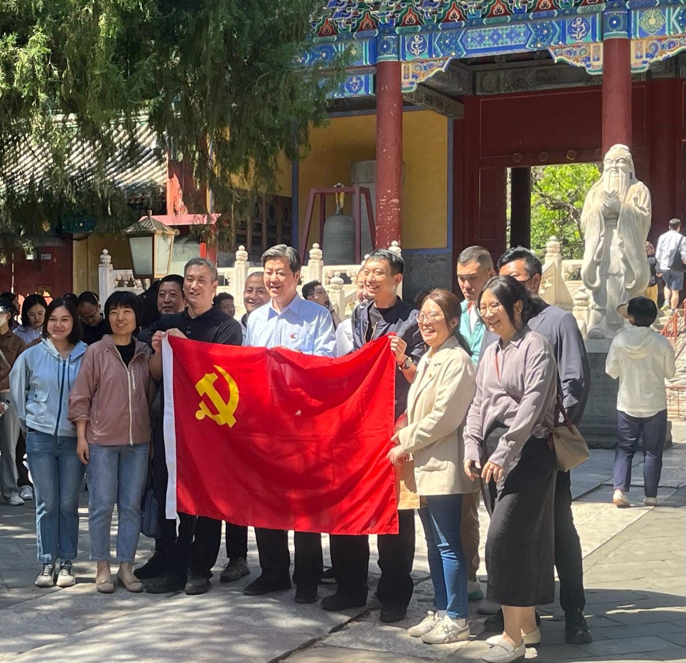 A group of people holding a flag

Description automatically generated