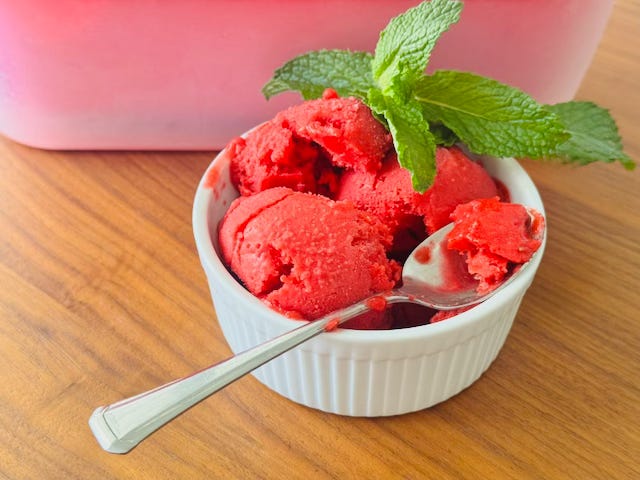 Homemade raspberry sorbet in a freezer-safe container, deep pink and glossy, made with fresh raspberries and churned in an ice cream maker Homemade raspberry sorbet in a freezer-safe container, deep pink and glossy, made with fresh raspberries and churned in an ice cream maker
