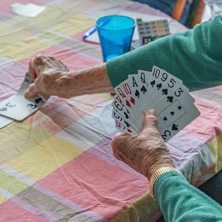 Diptych: Hands on lap sewing; Hands holding cards.