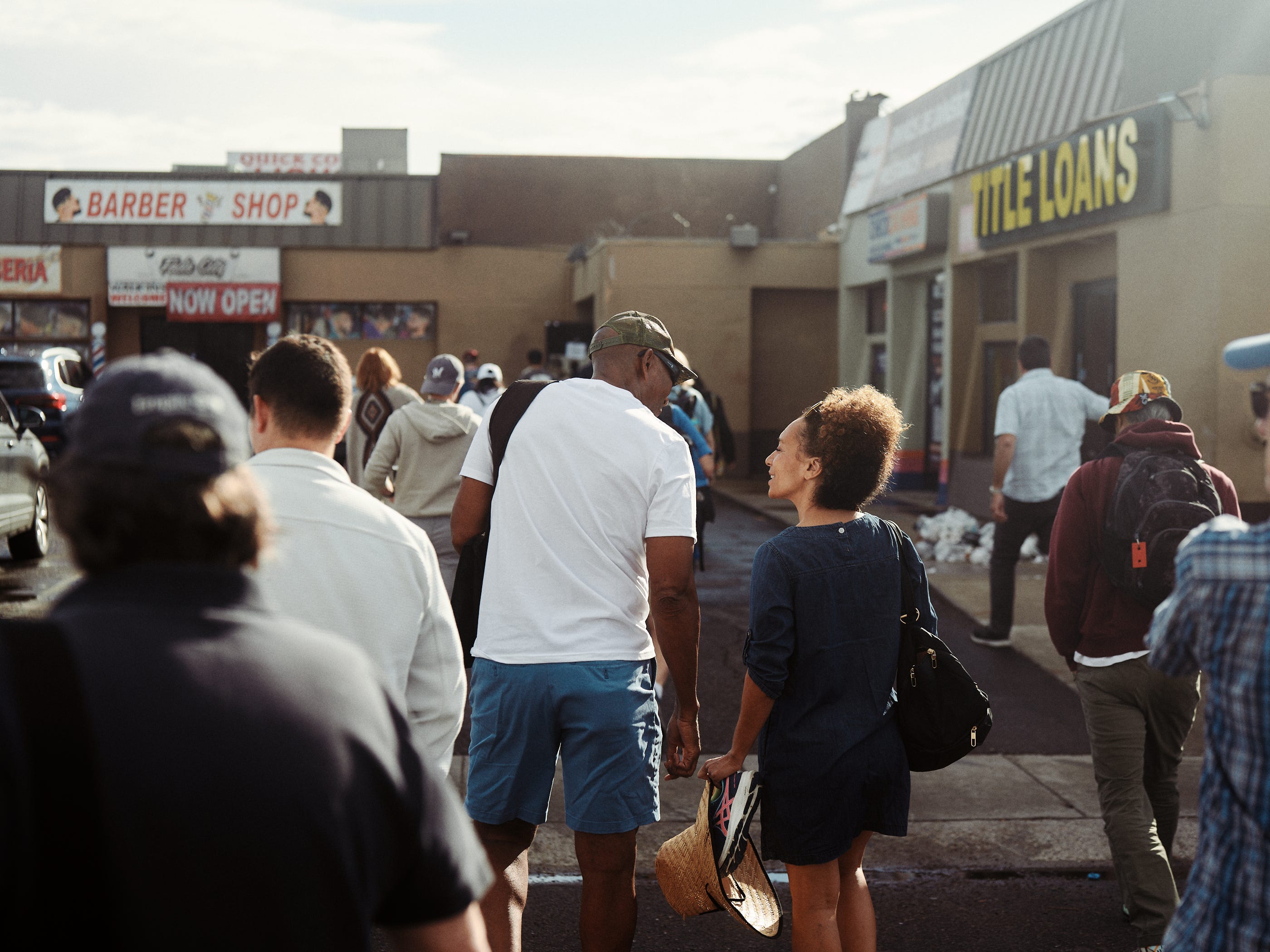 A group of people from Los Angeles walk towards the Harris Walz campaign office in Phoenix, AZ, photographed by Los Angeles portrait and documentary photographer Afonso Salcedo