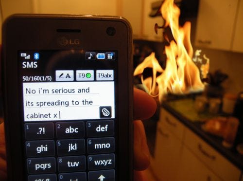 This may contain: someone is holding their cell phone in front of a fire This may contain: someone is holding their cell phone in front of a fire