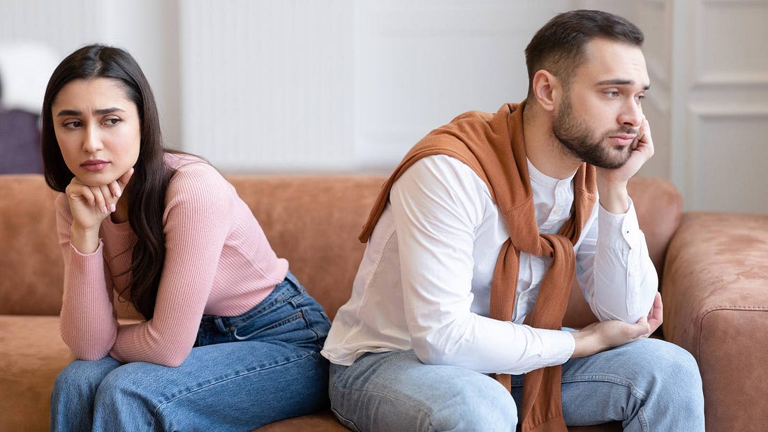 a woman and a man sitting together in sad silence