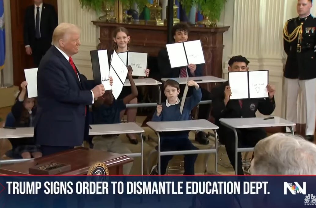 video screenshot showing Donald Trump holding up his signed executive order phasing out the Education Department, on a set with children sitting at school desks. Each kid holds up their own souvenir copy of the order, which they signed too. GROSS. NBC News chyron reads 'Trump signs order to dismantle Education Dept.' video screenshot showing Donald Trump holding up his signed executive order phasing out the Education Department, on a set with children sitting at school desks. Each kid holds up their own souvenir copy of the order, which they signed too. GROSS. NBC News chyron reads 'Trump signs order to dismantle Education Dept.'