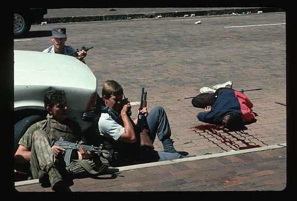 [NSFW] South African Police take cover from random gunfire during the Shell House Massacre. Johannesburg, 28 March, 1994.