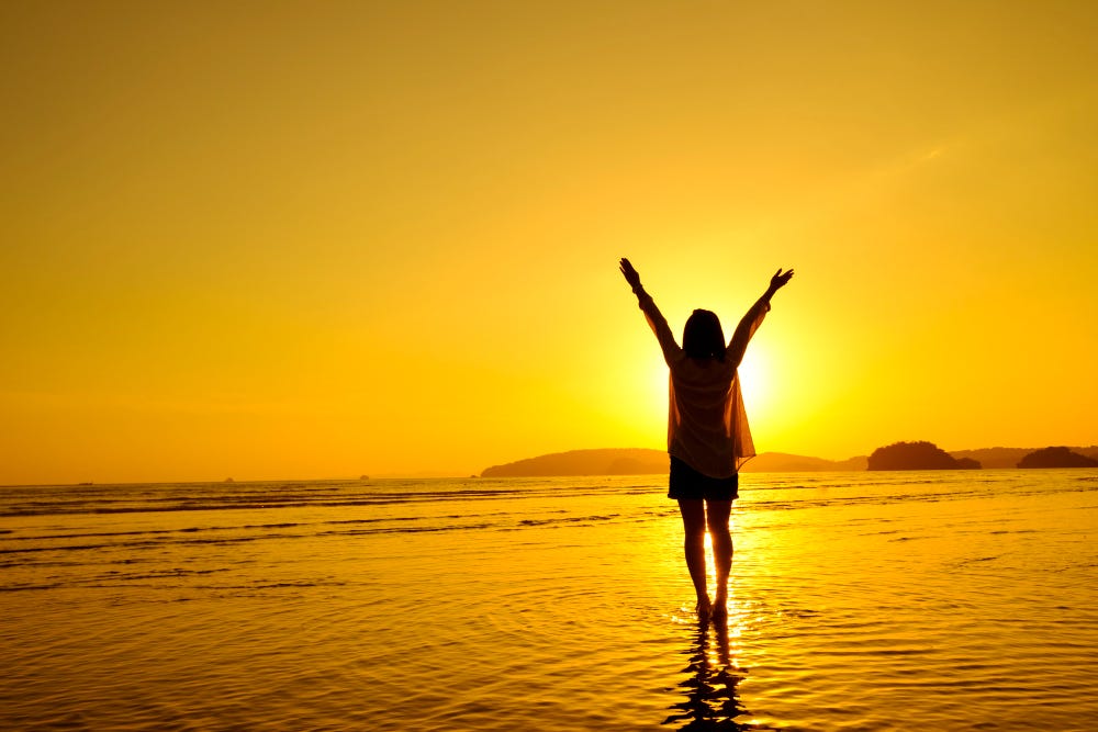 Young lady on a beach at sunrise, ready to take on the day!