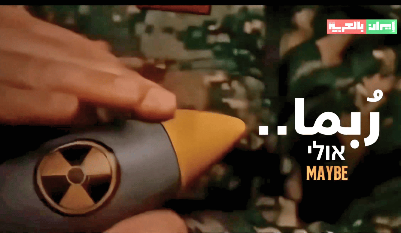 Still from a propaganda video posted by an Iranian state media outlet, showing a hand stroking what appears to be a mock nuclear bomb, accompanied by the word "maybe." 