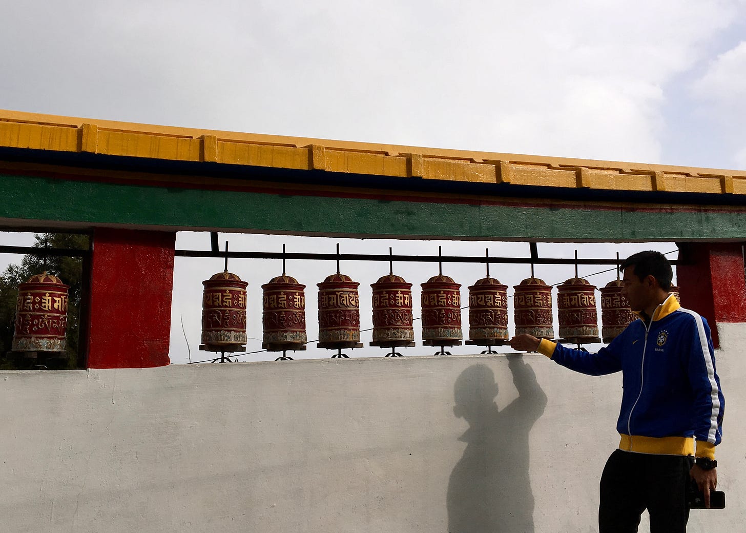 Person spinning prayer wheels at a Sikkim monastery as part of a traditional Buddhist practice.
