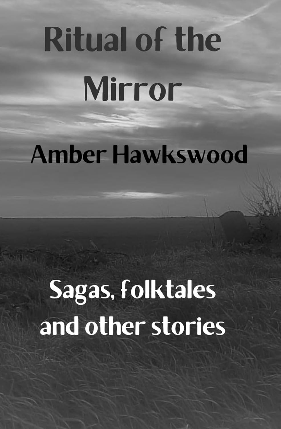 Black-and-white book cover of Ritual of the Mirror: Sagas, folktales and other stories by Amber Hawkswood. The text on the cover is placed atop a photo of open grassy land, presumably in Britain, with the horizon falling at the midpoint of the cover.