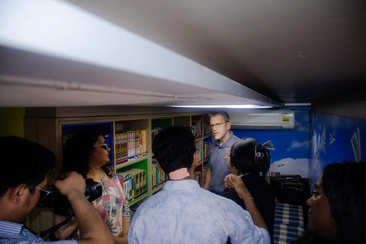 From left: HE Ambassador Dean Thompson exploring the Book Bus and students engaging with the Book Bus materials.